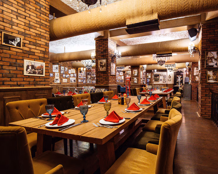 restaurant-hall-with-red-brick-walls-wooden-tables-pipes-ceiling_140725-8504